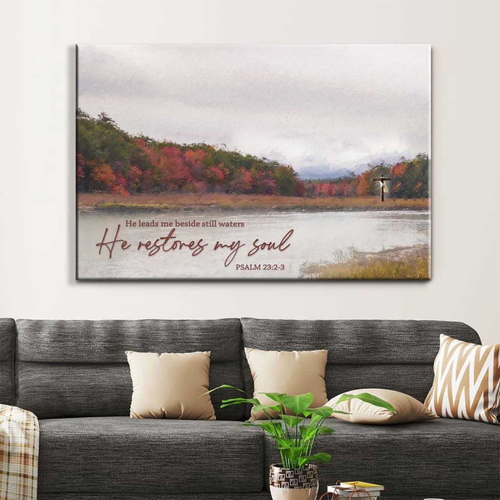 Christian wall art canvas with Psalm 23:2-3: "He Leads Me Beside Still Waters, He Restores My Soul," featuring a serene lake painting.