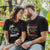 A couple wearing Christian-themed t-shirts sitting close together in an intimate moment.