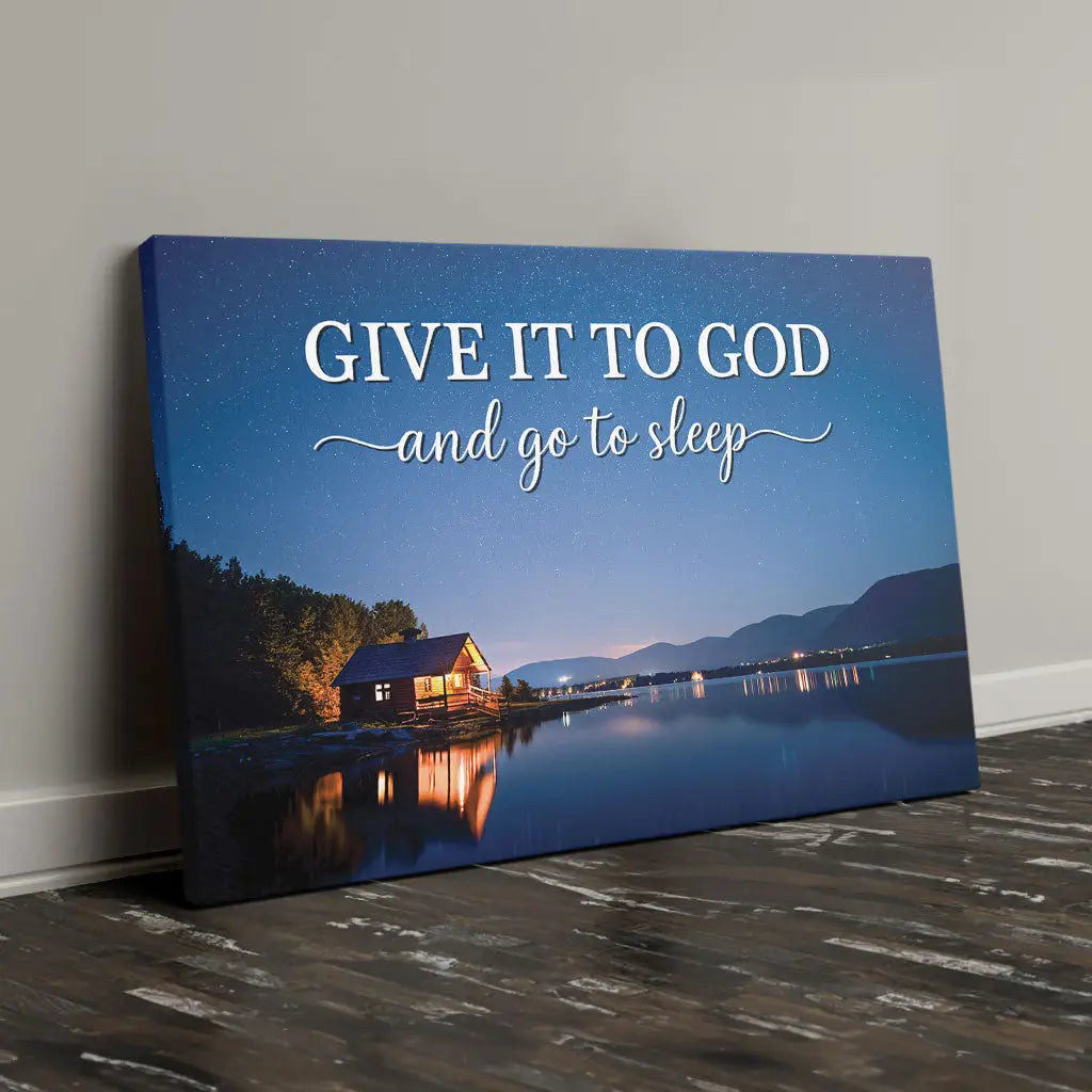 Give It to God and Go to Sleep wall art canvas featuring a cozy cabin by a starry lake.