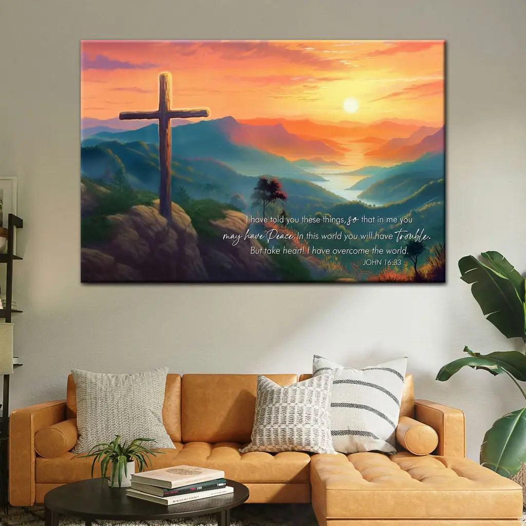 Christian wall art with John 16:33 NIV, "Take heart, I have overcome the world," featuring a cross and a sunset over mountains.