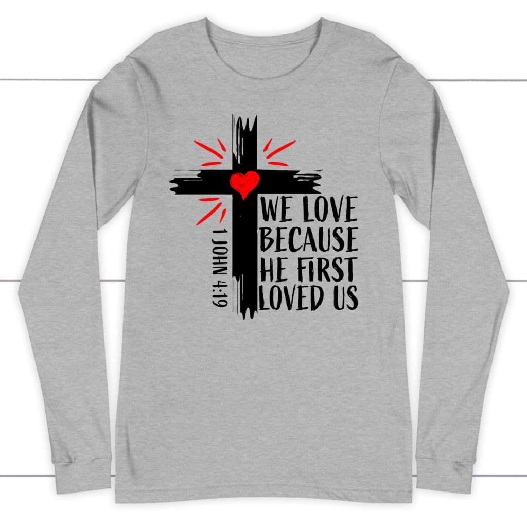 1 John 4:19 NIV We love because He first loved us Christian long sleeve t-shirt Athletic Heather / S