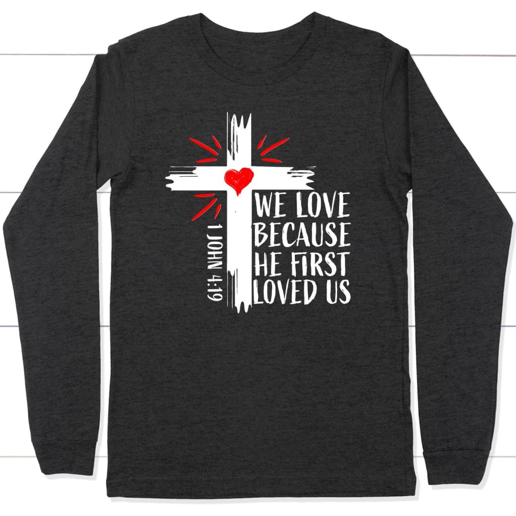 1 John 4:19 NIV We love because He first loved us Christian long sleeve t-shirt Dark Grey Heather / S