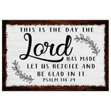 Inspirational Bible verse wall art, "This Is The Day The Lord Has Made" with rustic border on white canvas.