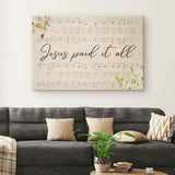 Jesus wall art featuring "Jesus Paid It All," with sheet music and lilies, perfect for religious home decor.